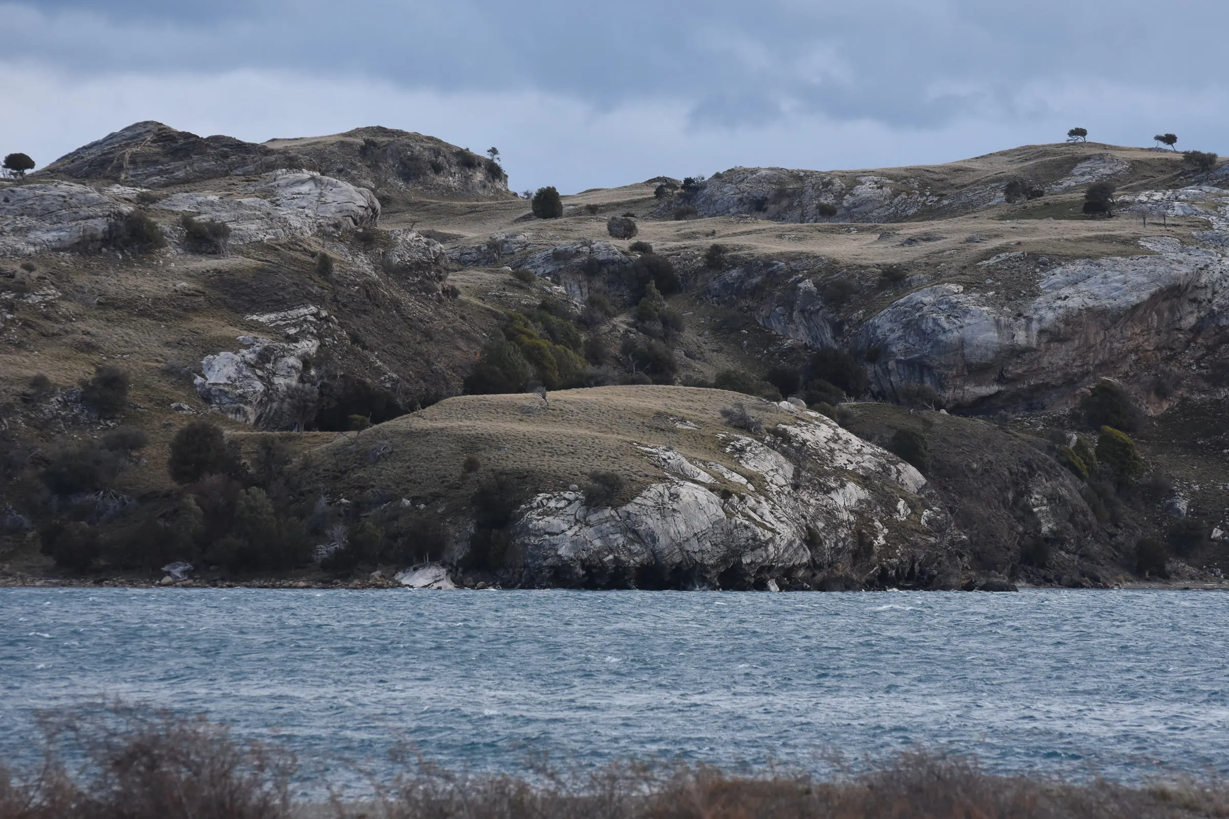 La orilla rocosa del lago con el agua picada