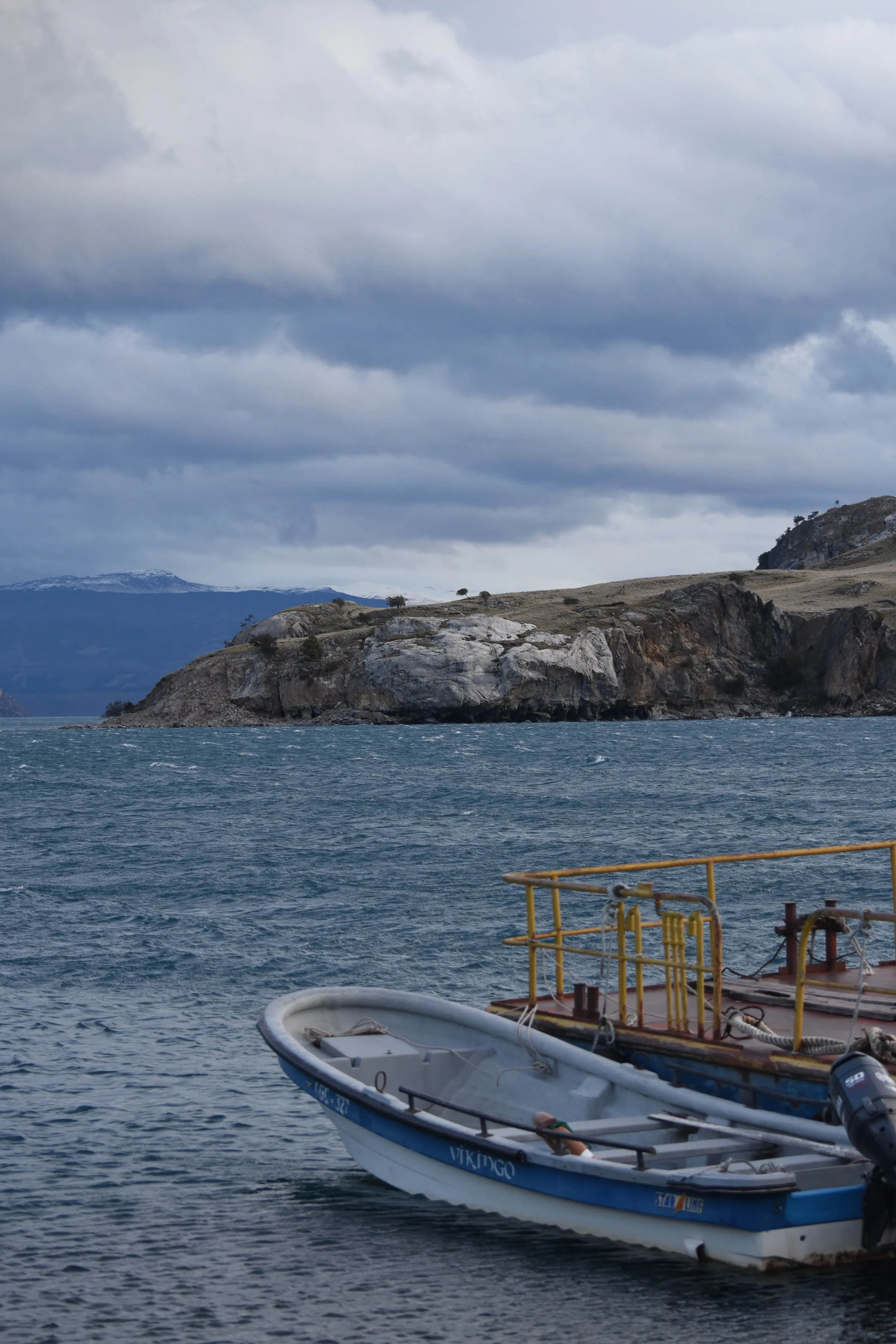 La orilla rocosa del lago con el muelle de hierro de Puerto Sánchez en primer plano