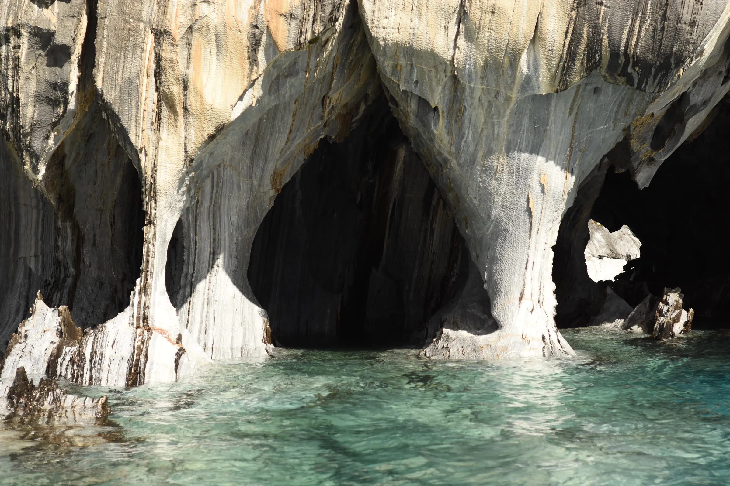 Las cavernas de mármol con el agua turquesa entrando bajo la piedra
