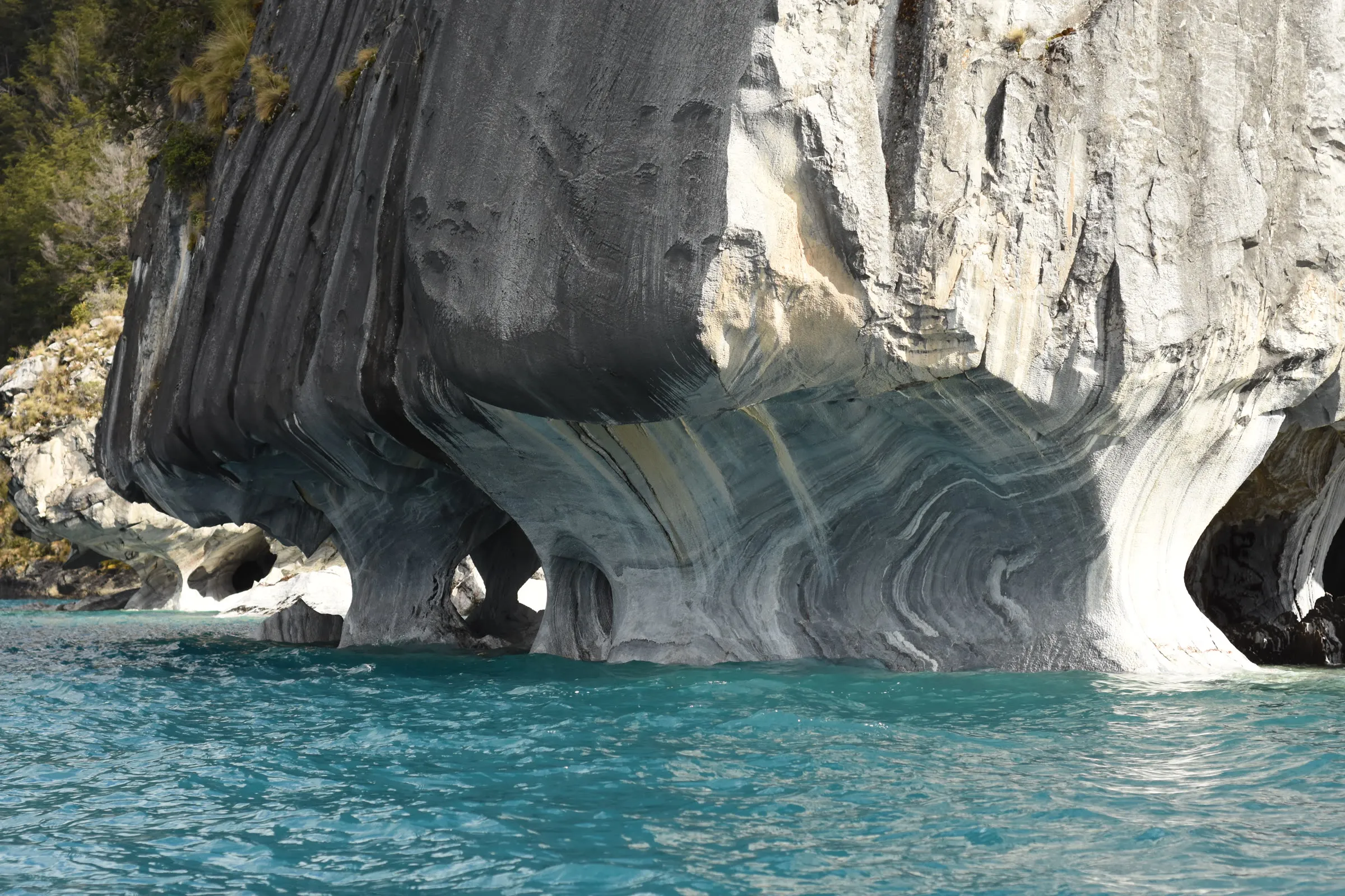 Un arco de mármol veteado sobre el agua turquesa
